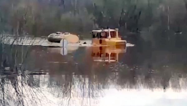 Видео: в Вельском районе трактор с молоком штурмует затопленную дорогу